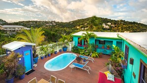 A rooftop pool area with a pool, lounge chairs, and potted plants. - St John Inn (St. John)