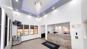 Ein Empfangsbereich mit einer Marmor-Theke, einer Chandelier und einem Empfangsschalter.