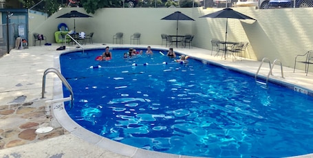 Una piscina al aire libre de temporada, sombrillas