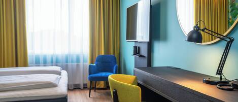 Une chambre d’hôtel avec un lit, un bureau, une chaise, une télévision et une lampe.