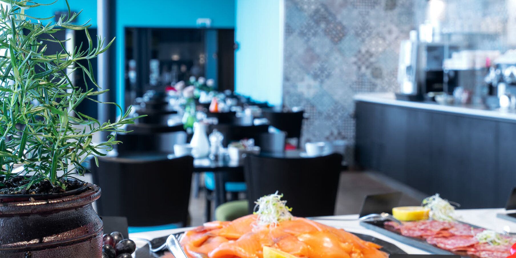 Un restaurante con una barra larga y varias mesas.