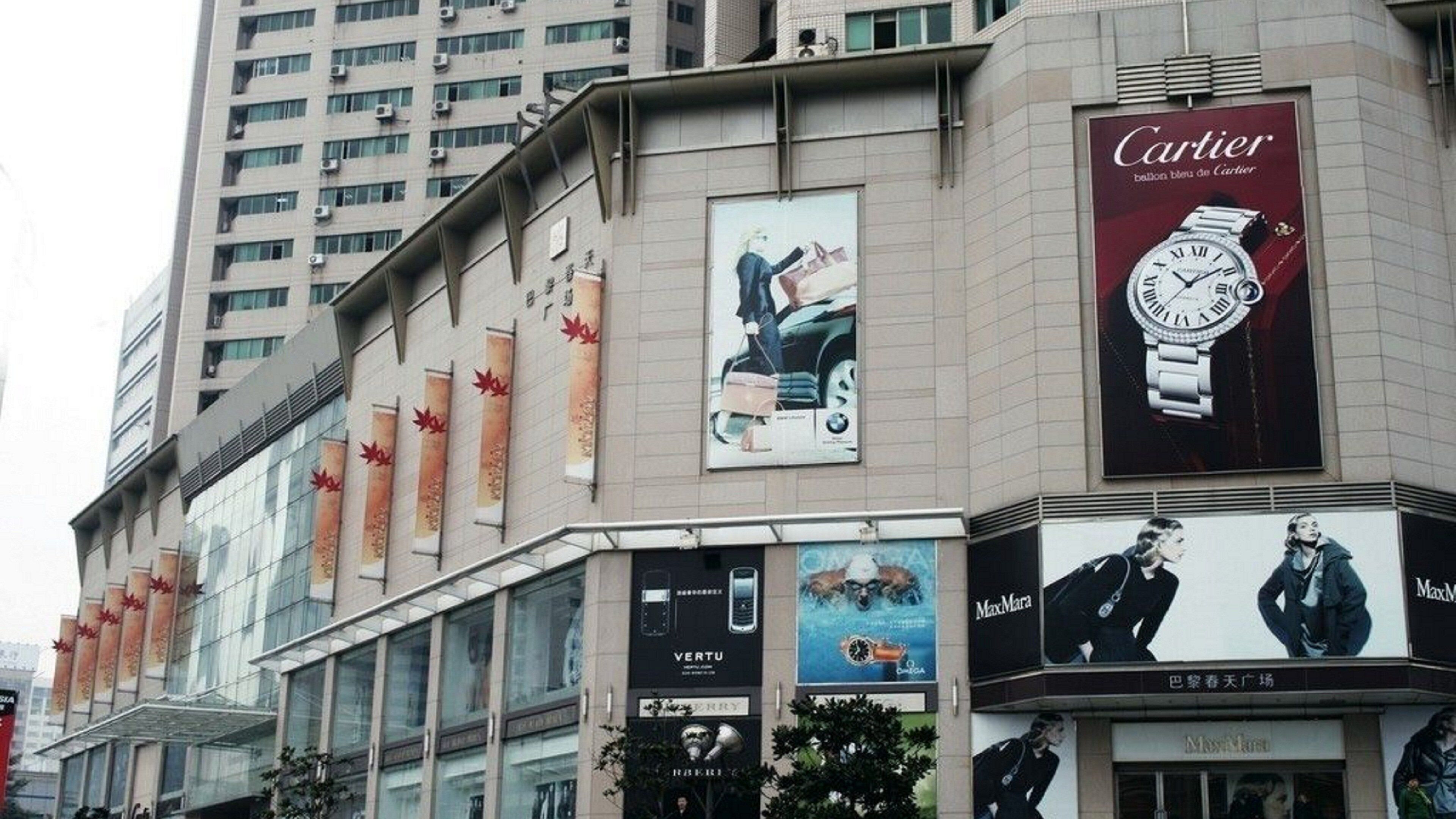 A commercial building with multiple advertisements, including a prominent Cartier watch ad.