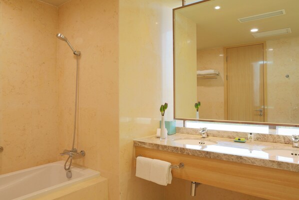 Une salle de bain équipée d’une baignoire, d’une douche, d’un lavabo, d’un miroir et d’un porte-serviettes.