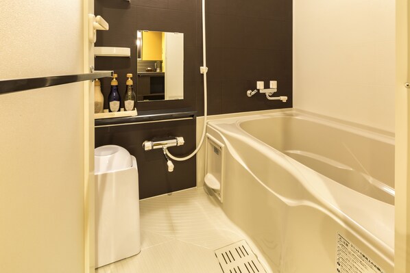 A modern bathroom with a bathtub, a toilet, a sink, and a mirror. - Biwako Hanakaido (Otsu)