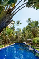 Una piscina al aire libre, sillones reclinables de piscina