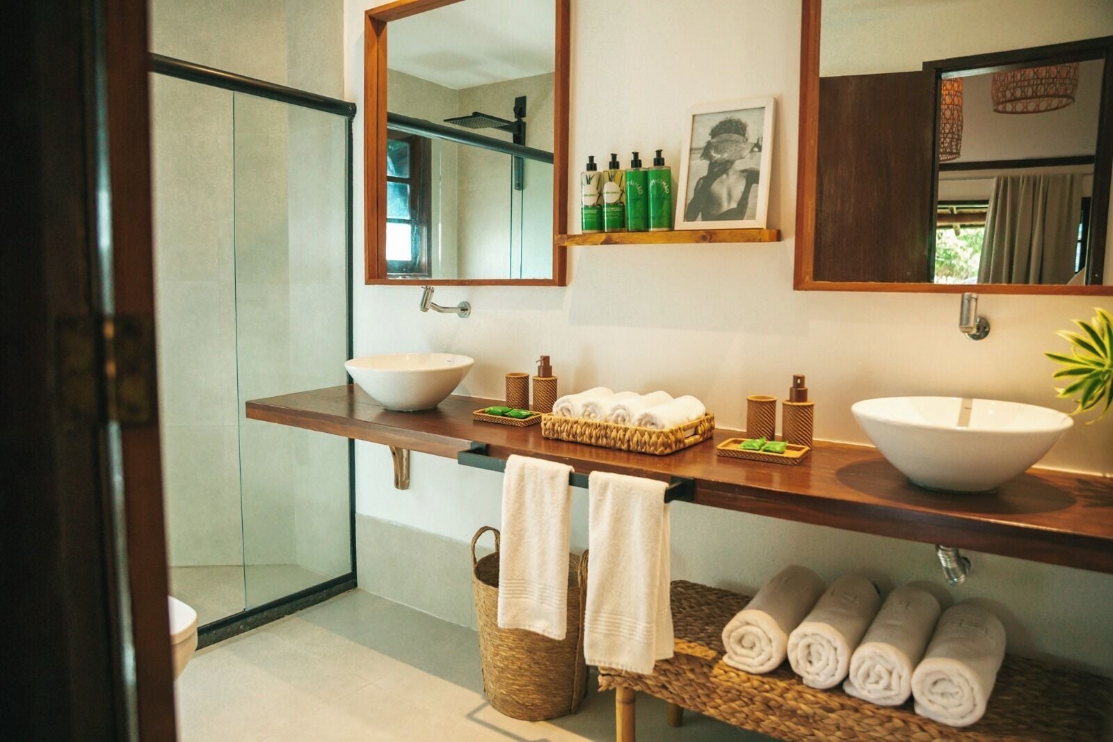 Ein Badezimmer mit einem großen Spiegel, zwei Waschbecken, einer Dusche und Handtüchern.