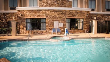 Una piscina con un muro de piedra y un letrero que indica que no se permite el clavado.