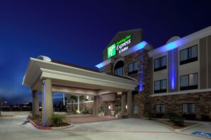 Un hôtel Holiday Inn Express & Suites doté d’une entrée couverte et d’une façade en briques.