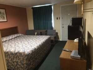 A hotel room with a bed, a desk with a computer and phone, a chair, and a window with curtains. - Elmwood Motor Lodge (Boscawen)