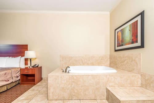 Suite, 1 très grand lit, non-fumeur, baignoire à jets | Lit avec matelas à plateau-coussin, bureau, rideaux d’obscurcissement