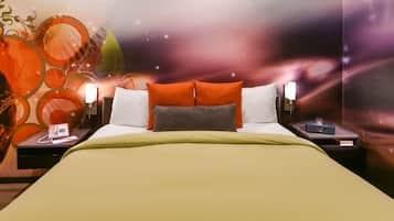 A hotel room with a bed, two bedside tables, a telephone, and a wall with a space-themed mural.