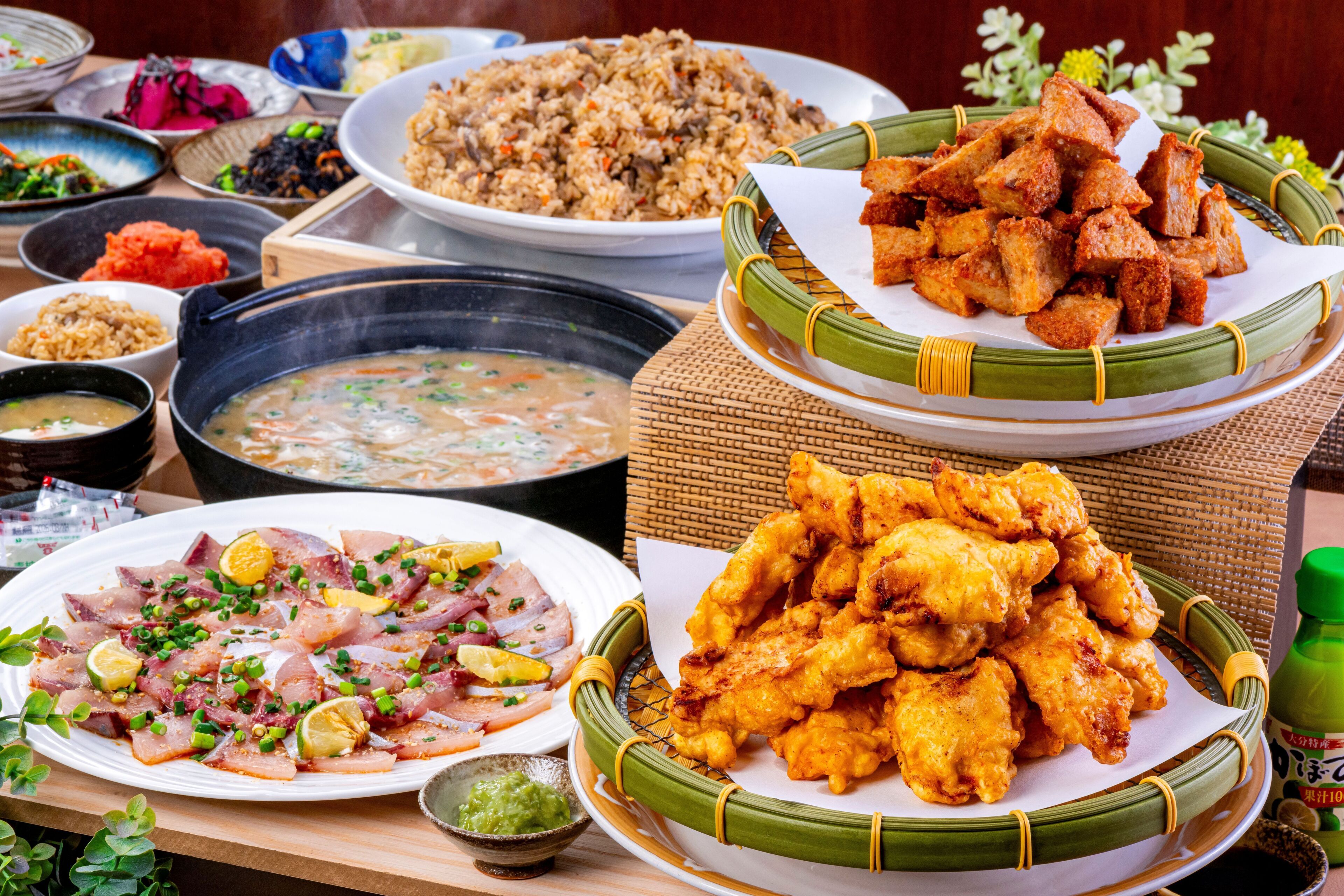 A variety of dishes including fried items, a bowl of soup, and a plate of sliced meat with garnishes.