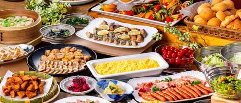 Una mesa de buffet con diversos platos, incluyendo mariscos, ensaladas y pan.
