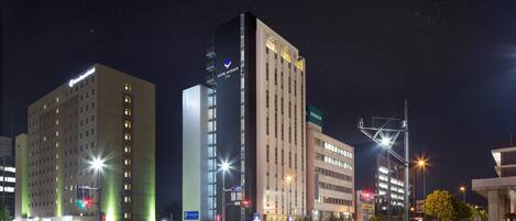 A hotel with multiple floors, a prominent sign, and a parking sign.