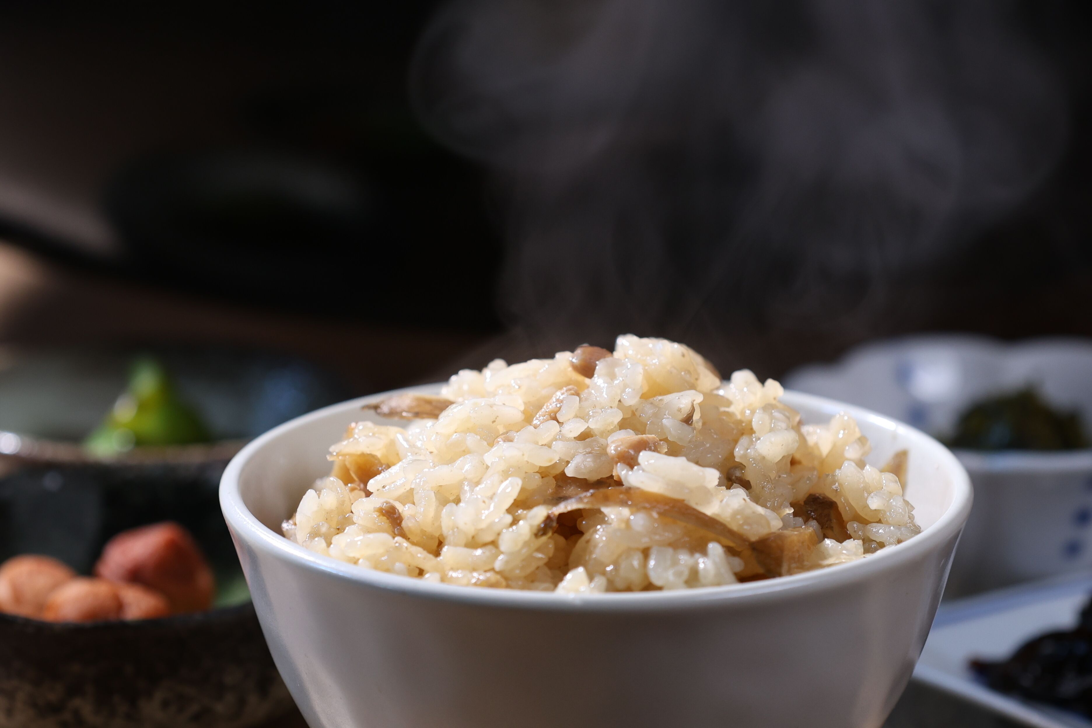 A bowl of rice with steam rising from it.