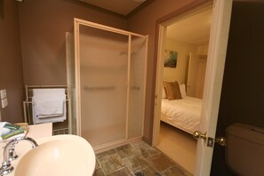 A bathroom with a sink, a towel rack, and a shower enclosure. - Cottages at Monreale (Olinda)