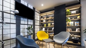 Un espacio de oficina moderno con un escritorio, dos sillas, una estantería y una planta en maceta.