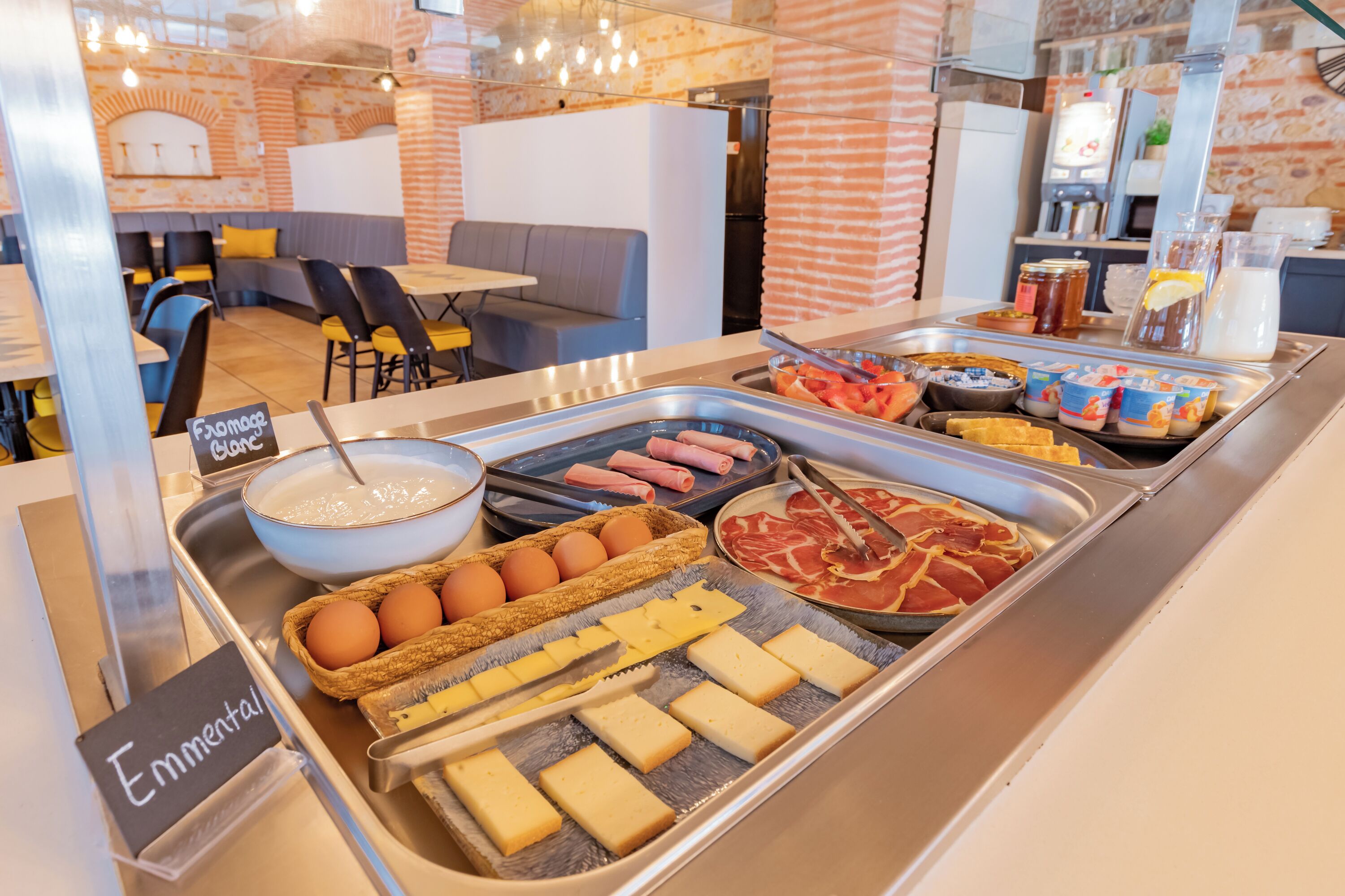A buffet with various food items including eggs, meats, and cheeses.