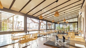 A spacious indoor dining area with high ceilings, large windows, and wicker furniture. - Mar I Sol (Saint-Cyprien)