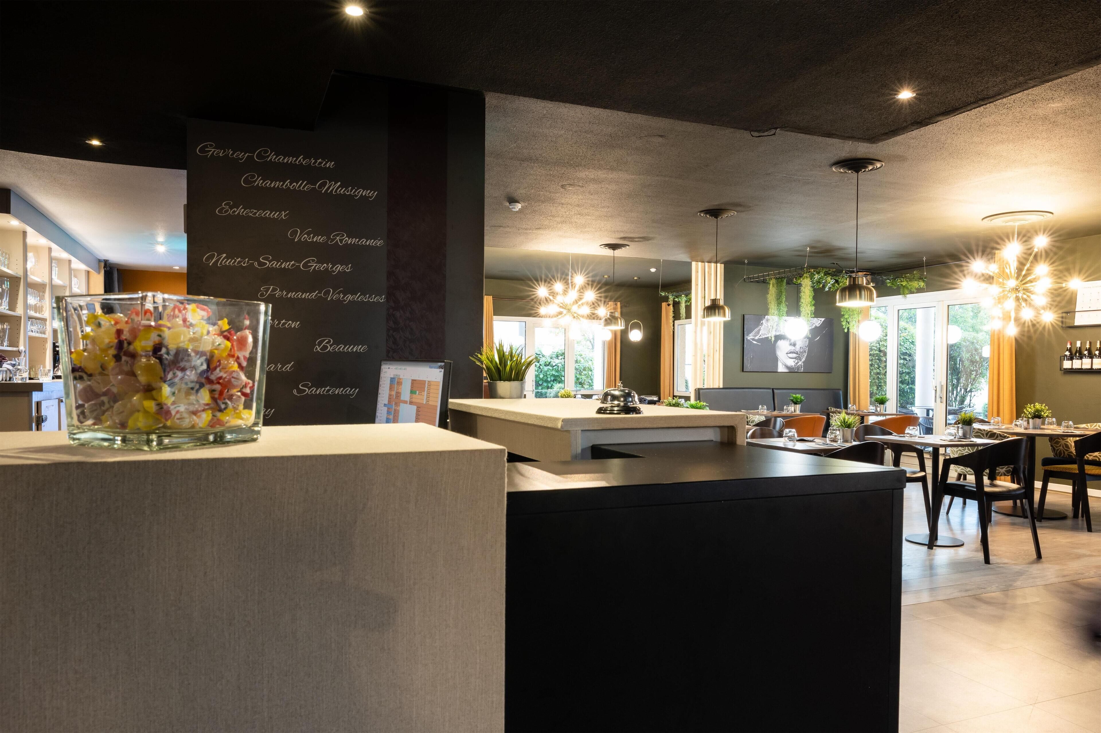 A modern restaurant interior with a central island, pendant lighting, and a menu board listing various dishes.