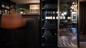 A bar area with a wine rack, a seating area, and a potted plant. - Tulip Inn Beaune (Beaune)
