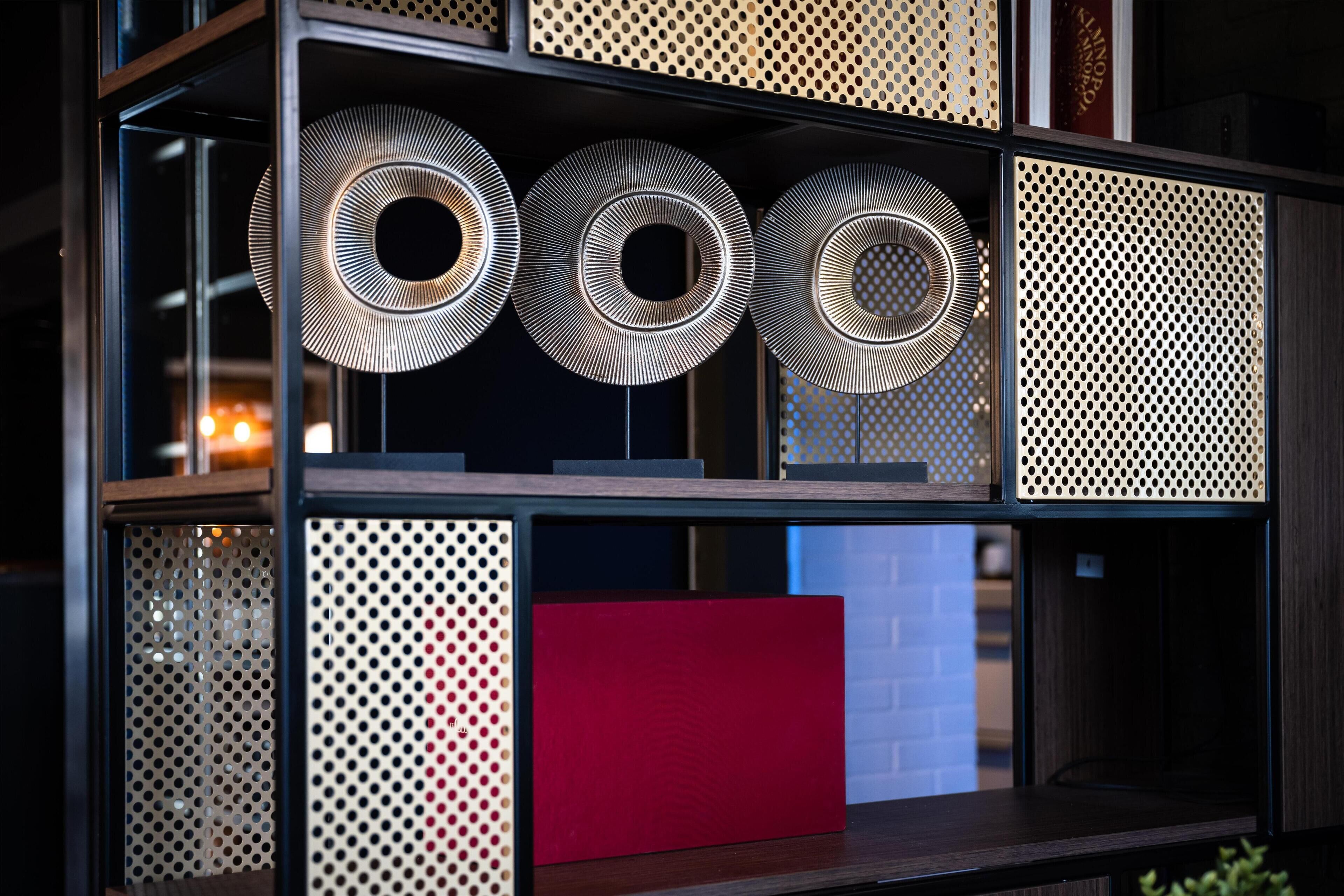 A shelf with three circular objects and a red rectangular object.