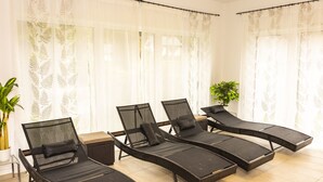 A room with four black lounge chairs with cushions, a small table, and a potted plant. - Alpenhotel Ensmann (Goestling an der Ybbs)
