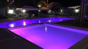 Una piscina al aire libre de temporada, sillones reclinables de piscina