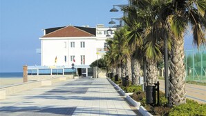A white building with a brown roof, a sign reading "Hotel Strand," and a clear view of the beach. - Hotel Strand (Montenero di Bisaccia)