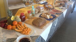 A buffet table with various food items, including fruits, bread, and condiments. - Hotel Strand (Montenero di Bisaccia)