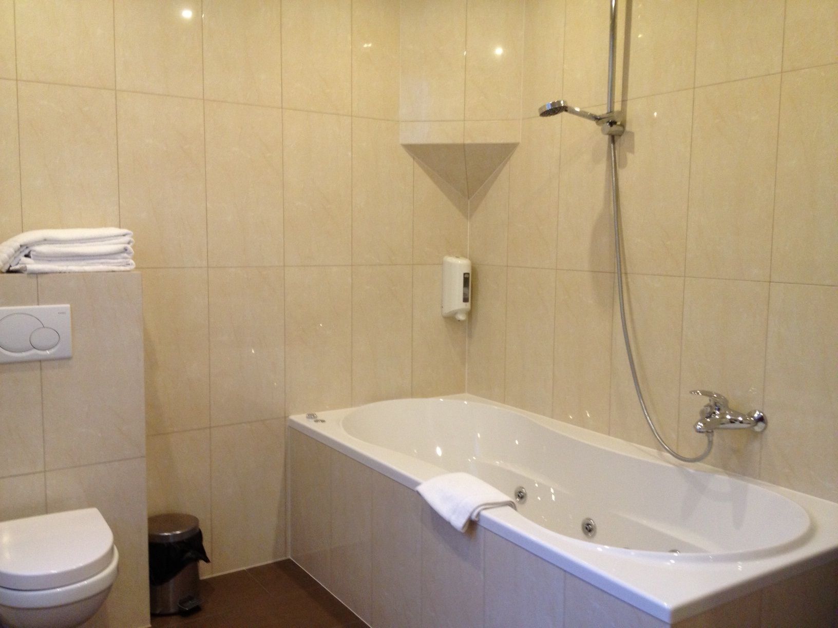 Een badkamer met een bad, toilet en handdroger.
