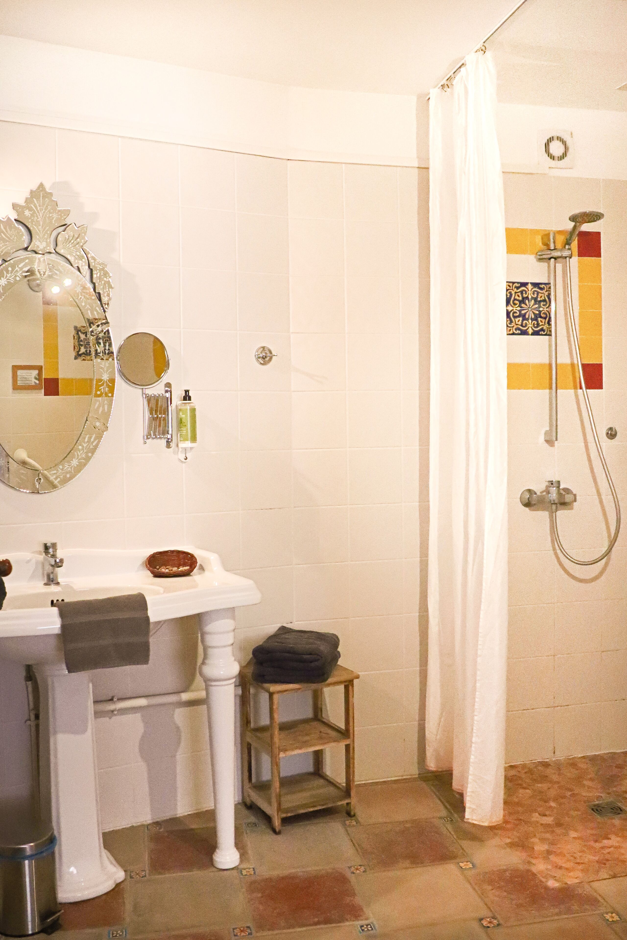 Un baño con lavabo blanco, espejo y ducha.