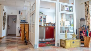 Una habitación amplia con un ventanal grande, un aparador de madera, un escritorio y una alfombra colorida.