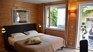 Un dormitorio con paneles de madera, una cama, un reloj en la pared y una ventana con cortinas.