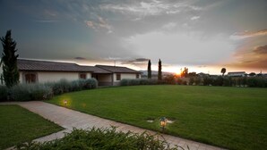 A residential area with a paved pathway, a lawn, and a building with a tiled roof. - Agriturismo Le Rondini di Francesco di Assisi (Cannara)