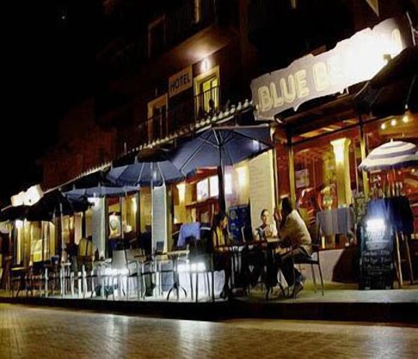 A hotel with outdoor seating and umbrellas. - Blue Beach (CAN PICAFORT)