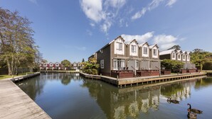 Una hilera de casas modernas con un cuerpo de agua tranquilo al frente.