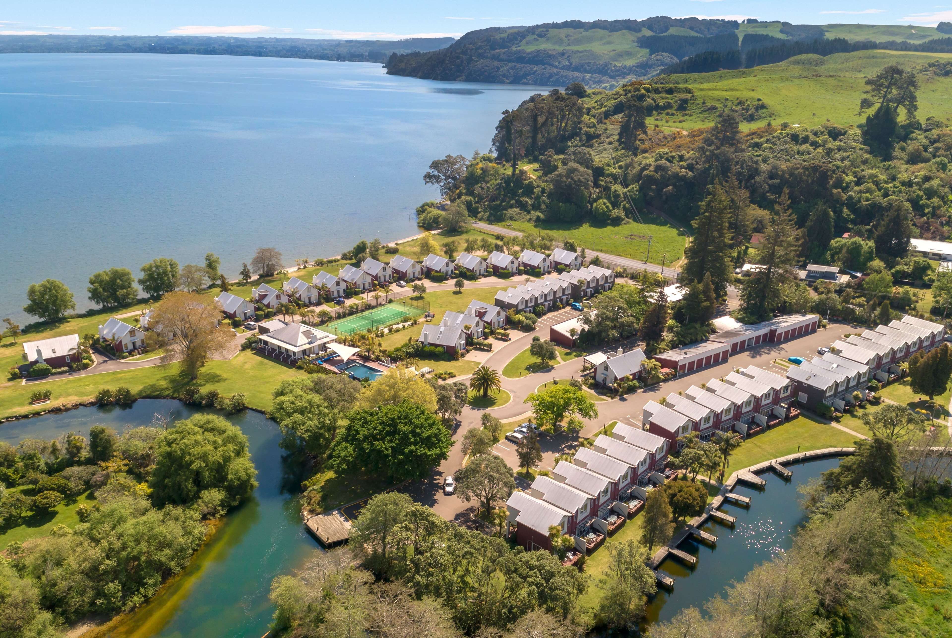 A lakeside residential area with multiple houses and a small dock.