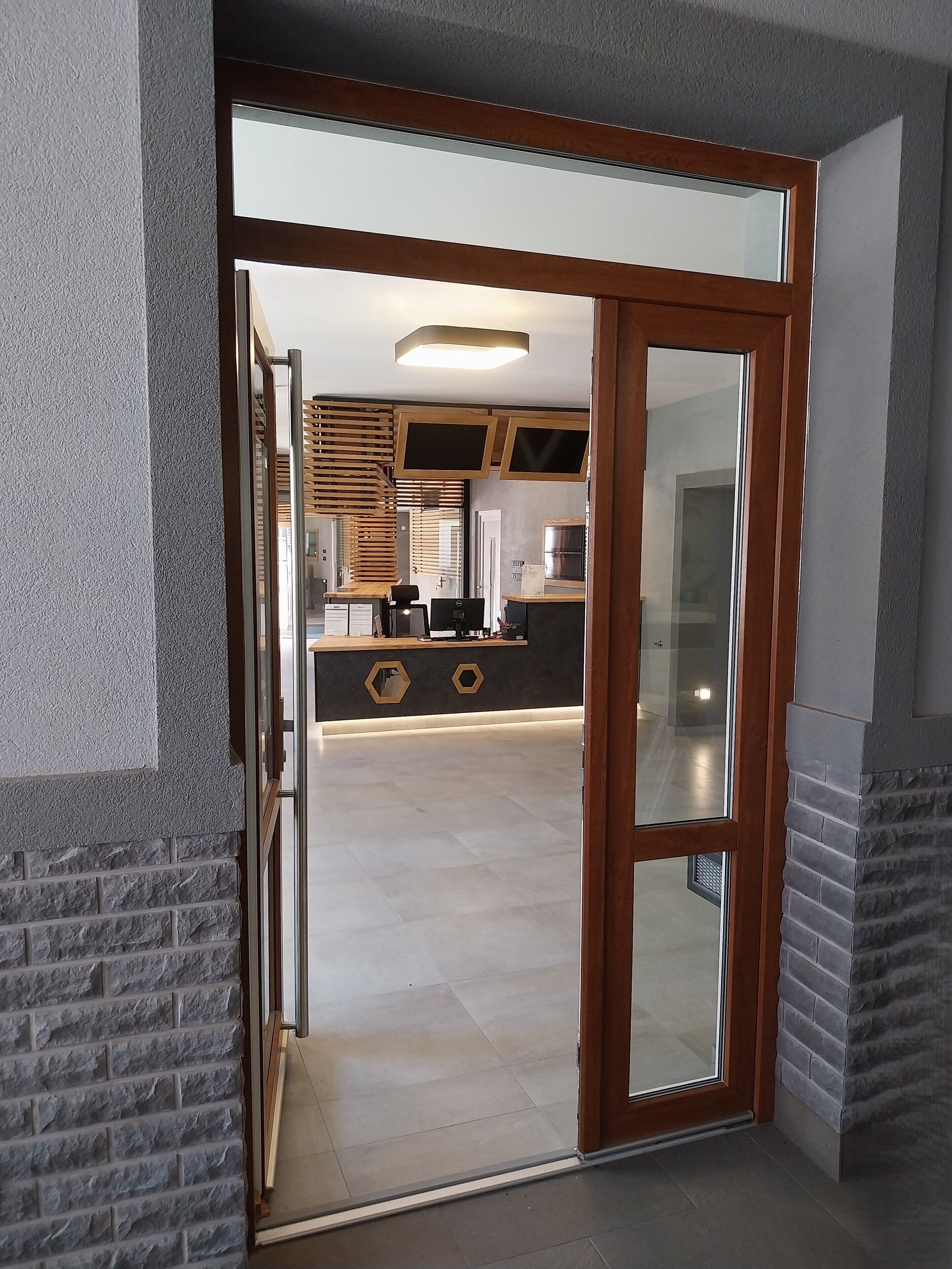 Puerta abierta que da a una cocina moderna con una isla central, electrodomésticos integrados y vista al área de estar contigua.