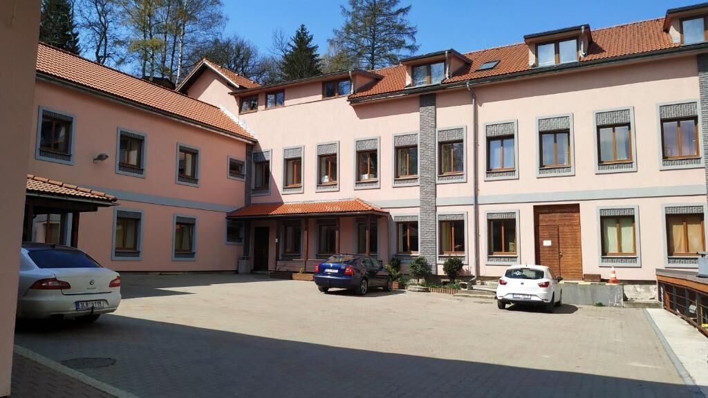 A multi-story building with a central courtyard, featuring a car parked in the middle.