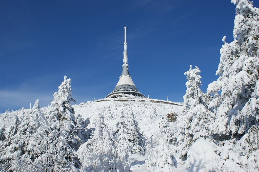 Una montaña cubierta de nieve con una estructura alta y cónica en la cima.