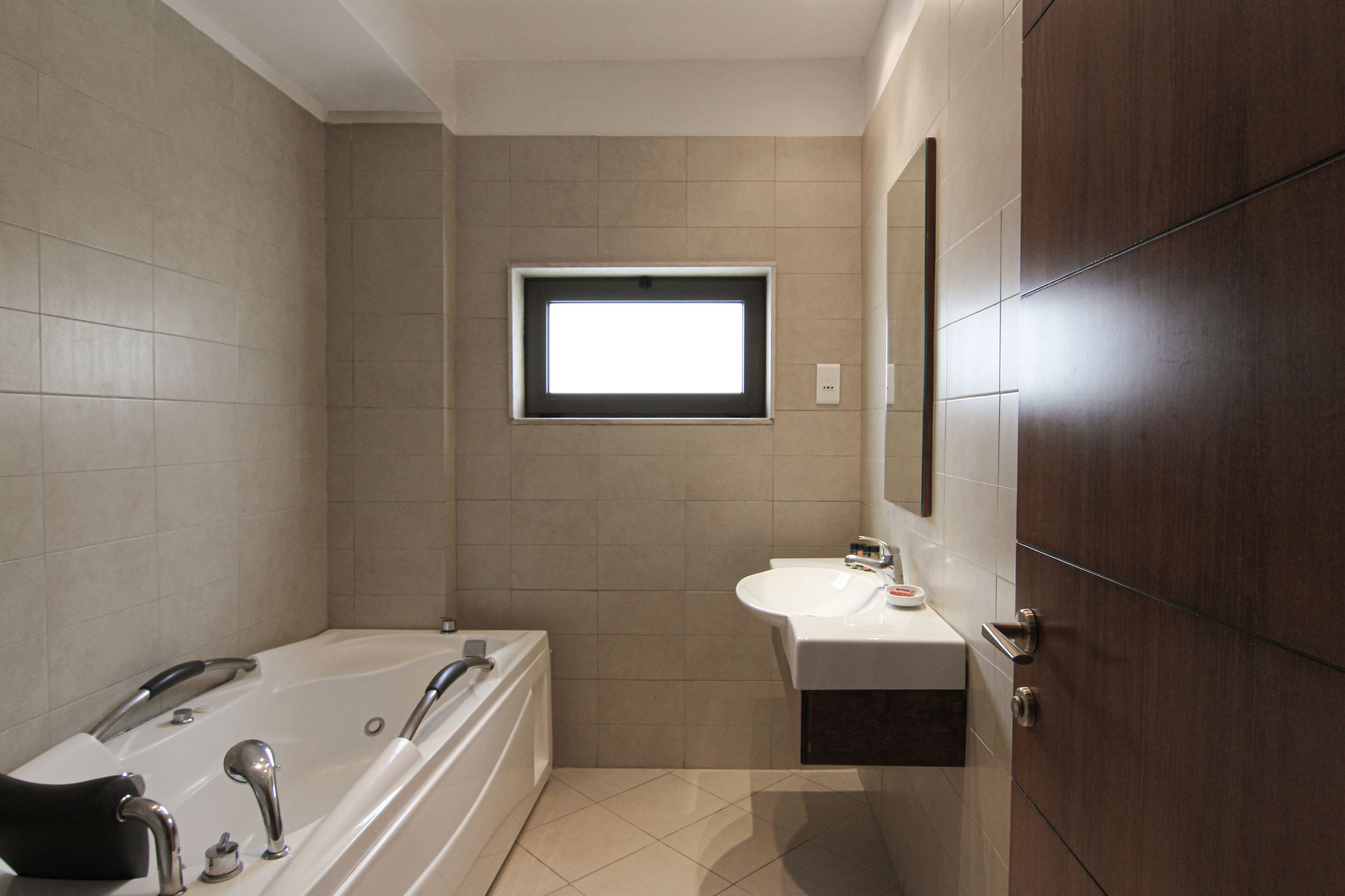 Une salle de bain moderne avec une baignoire, un lavabo et une fenêtre.