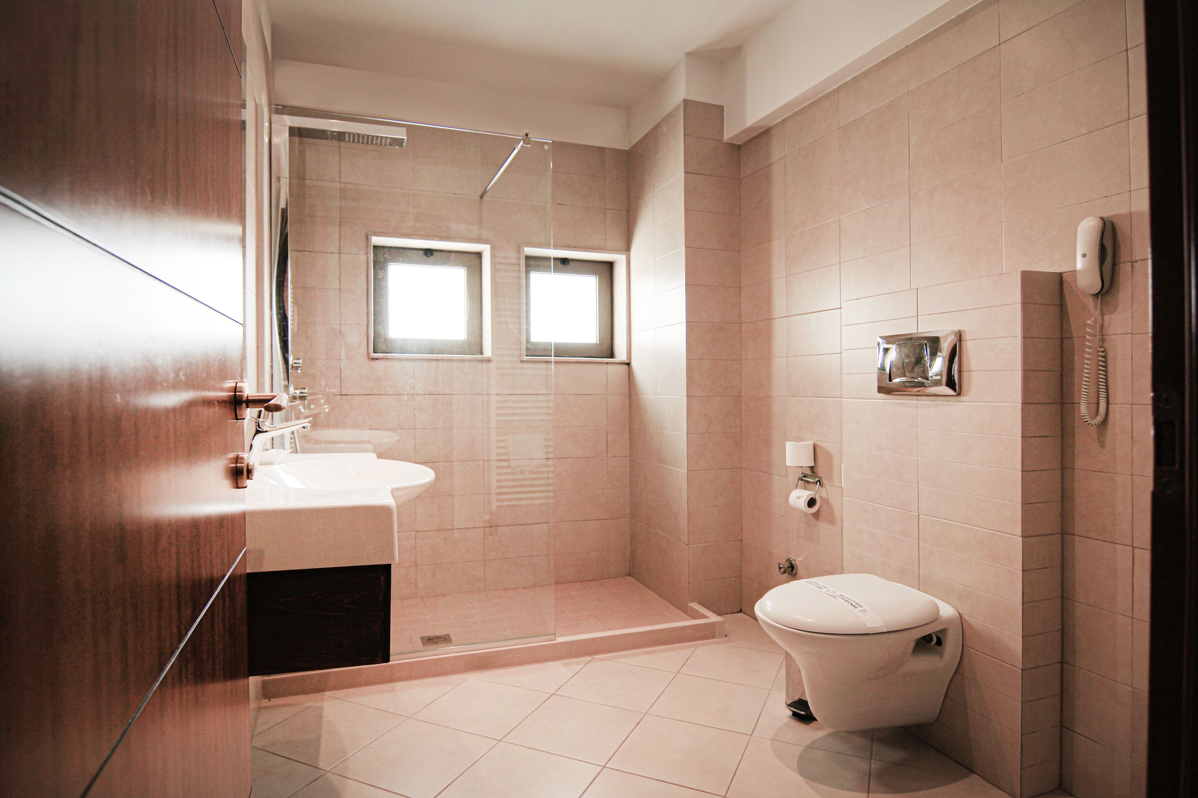 A modern bathroom with a shower, toilet, and sink.