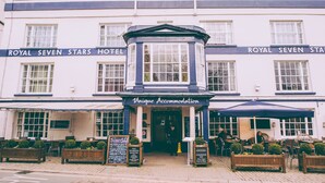 The exterior of the Royal Seven Stars Hotel with a sign for Unique Accommodation. - Royal Seven Stars Hotel (Totnes)
