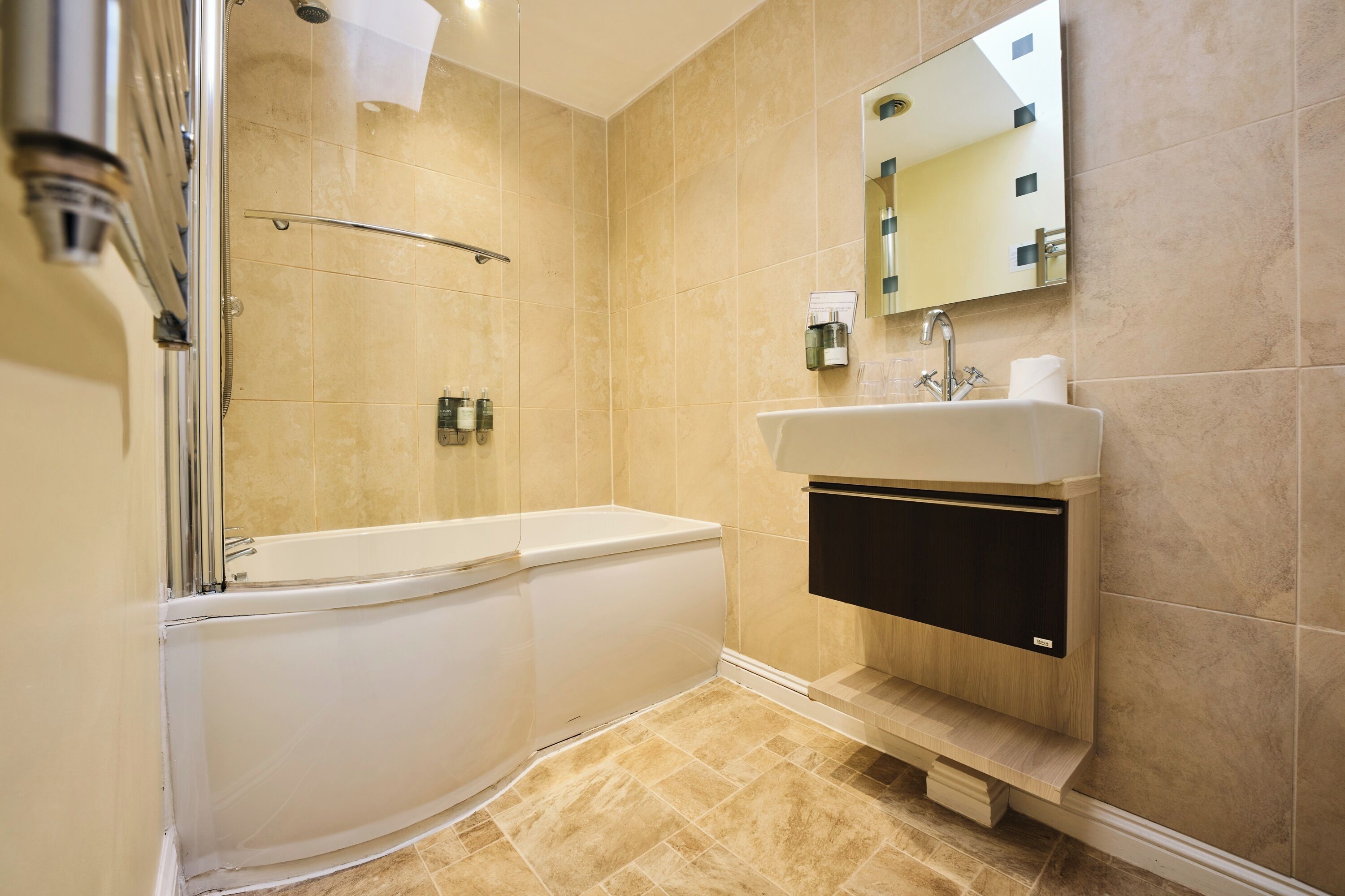 Une salle de bain moderne avec une baignoire, un lavabo et un espace douche.