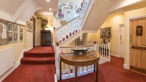 A grand staircase with a glass table at the bottom, leading to a room labeled "ROOM IN USE". - Royal Seven Stars Hotel (Totnes)