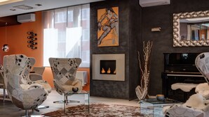 A modern living room with contemporary furniture, a fireplace, and a large mirror. - BEST WESTERN Hotel Vista (Ostrava)