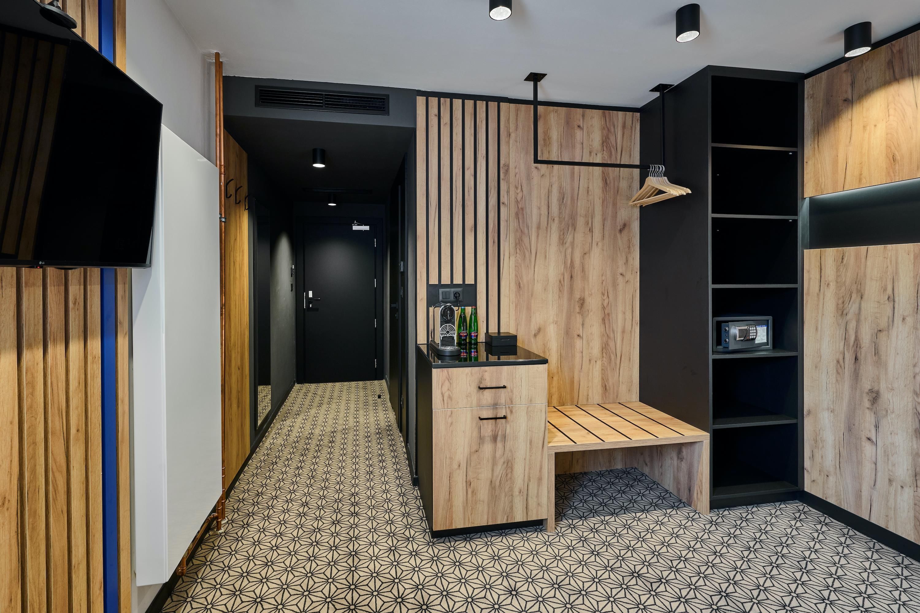 Une salle de bain moderne avec un meuble-lavabo en bois, un banc et une étagère sur laquelle se trouve un four à micro-ondes.