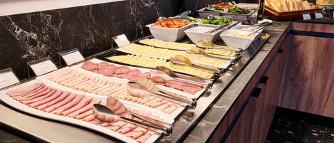 A buffet with various food items and utensils.