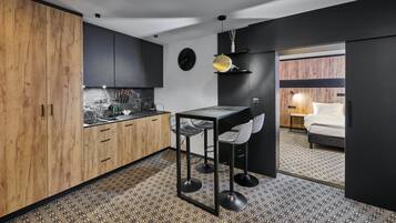 A modern kitchen with a marble countertop, wooden cabinets, and a bar area.